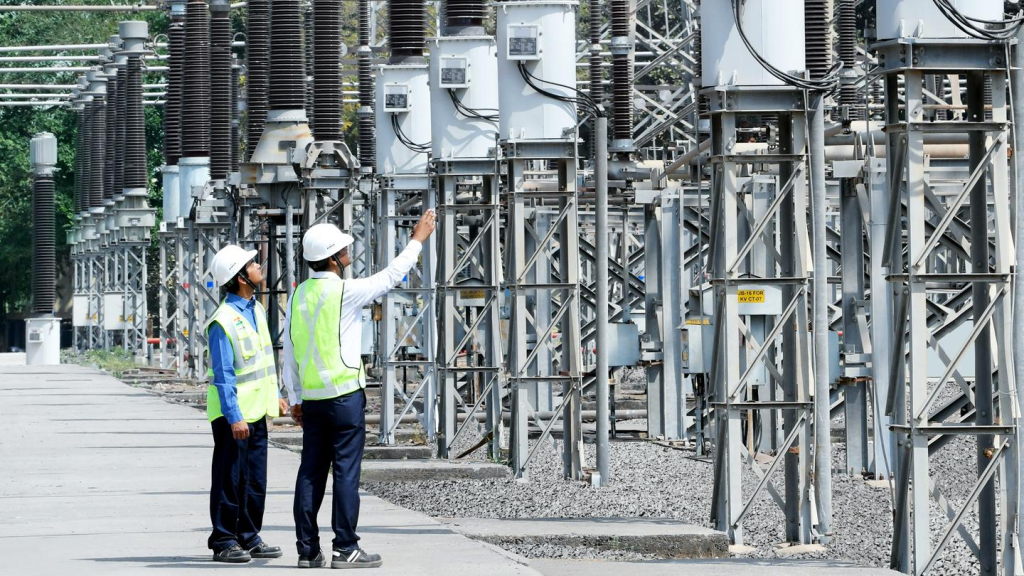 At the installation site of Air Insulated Switchgear in modern industrial parks or substations, the equipment is neatly arranged, and technicians are patrolling and inspecting. The overall environment is bright and professional, reflecting a modern power distribution system.