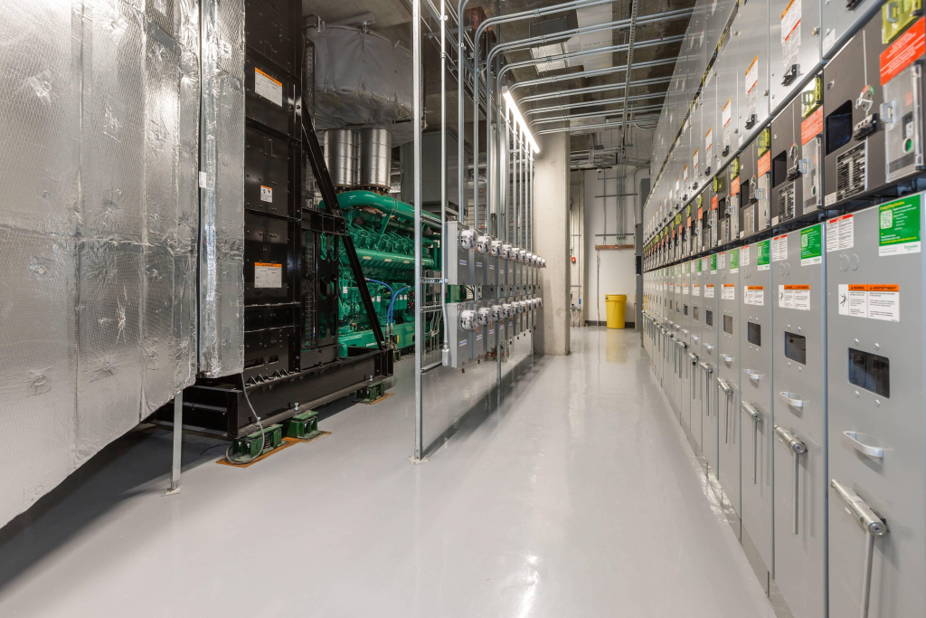 A smart data center power infrastructure featuring Medium Voltage Switchgear, UPS systems, backup generators, and digital energy monitoring platforms. Include control room displays to illustrate intelligent, resilient, and future-ready electrical distribution.